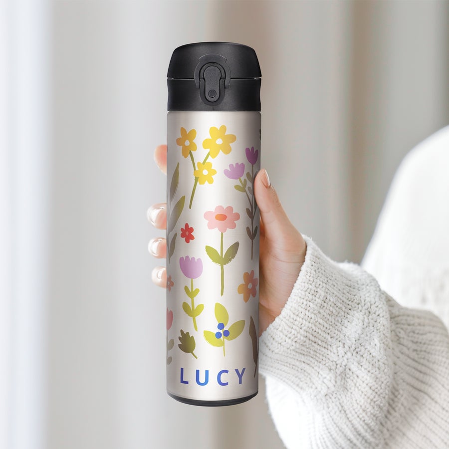 Personalised Metal Water Bottles A hand holding a personalized metal water bottle with a printed floral design and the name Lucy on it