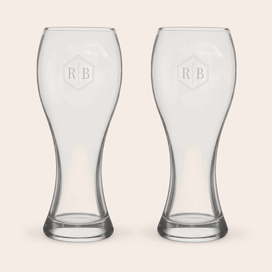 A pair of customized xl beer glasses, each engraved with the letters RB within a hexagonal design.