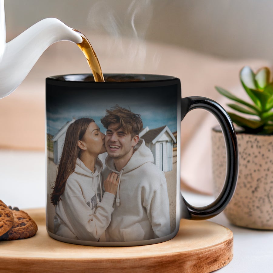 Personalised magic mug A black Personalised Mug - Magic with a custom printed photo of a couple on a beach, hot tea pouring in, making the image appear