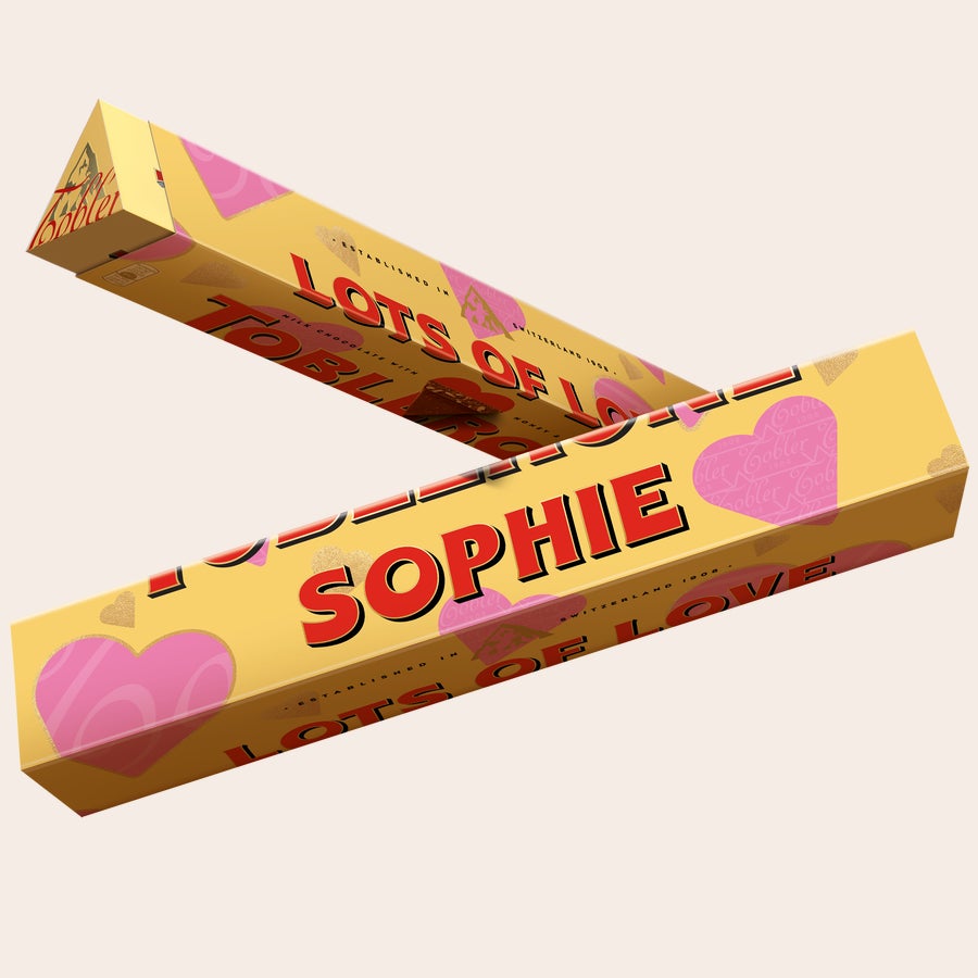 Personalized Toblerone bar printed with the name Sophie and Lots of Love surrounded by pink and gold hearts.