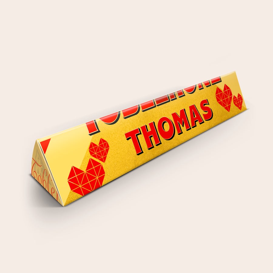 Personalized Toblerone bar with a name and photo, printed with the name THOMAS and red geometric hearts.