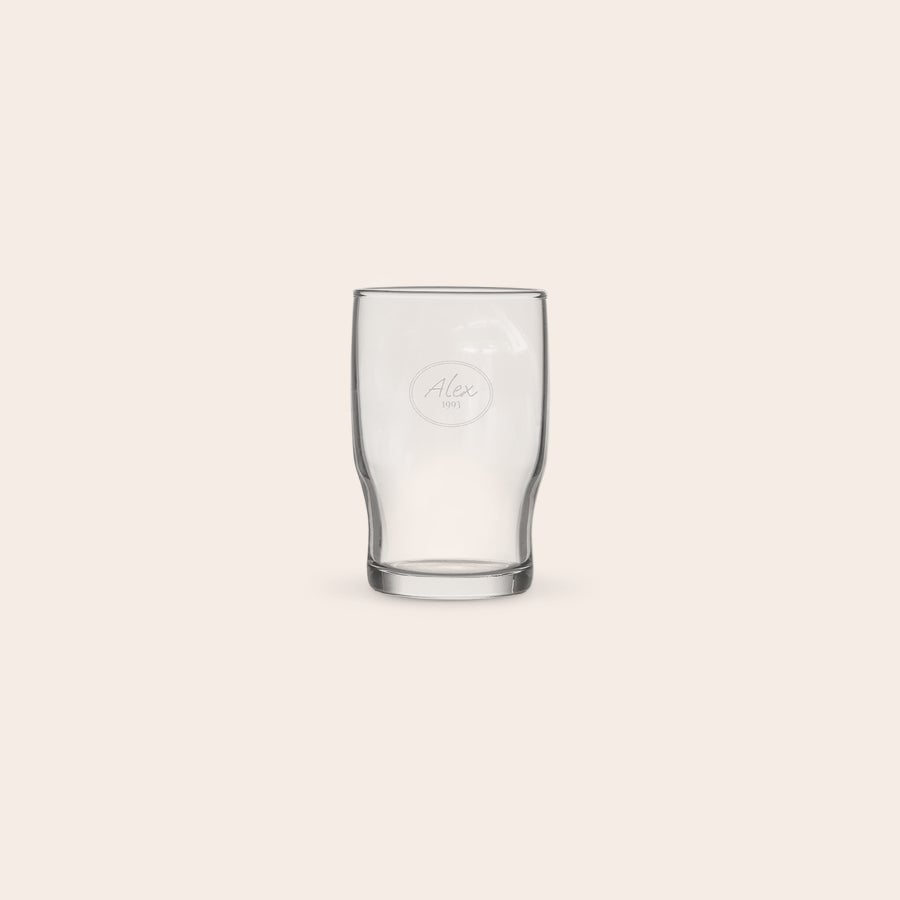 A personalized water glass with the name Alex engraved within a circle design