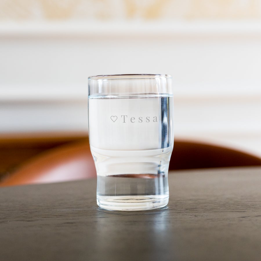 Personalised water glass Personalised water glass engraved with the name Tessa and a small heart icon, filled with water