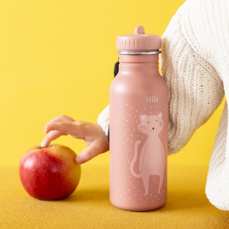 Personalised Trixie water bottle with cat design and Mila engraved, next to an apple.